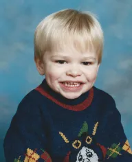 Profile picture: a pre-school headshot of me wearing a "Thomas the Tank Engine" knitted jumper in front of a blue cloud background